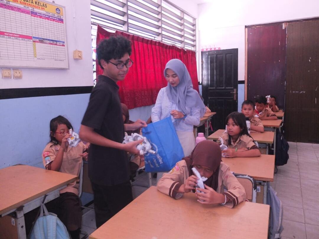 Mahasiswa membagikan hadiah pada seluruh siswa/i